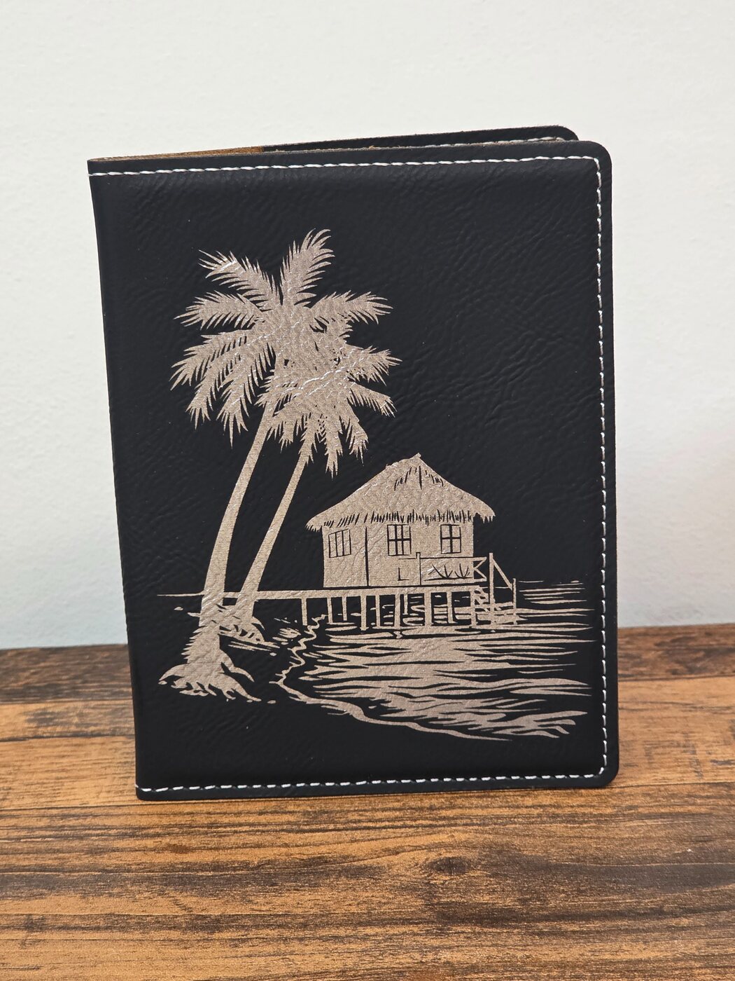 Black passport cover engraved with an island scene